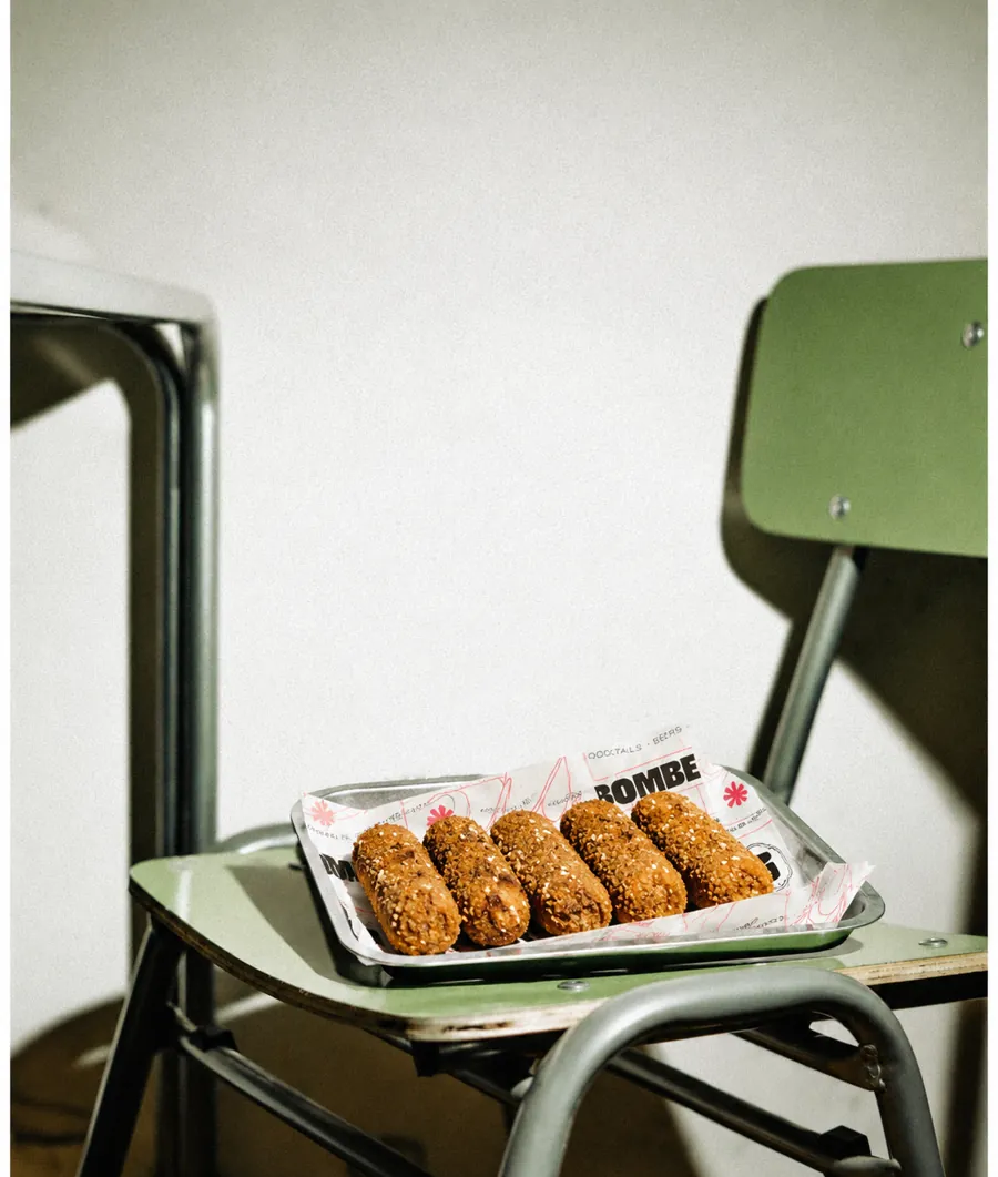 Kroketten op een BOMBE-tray op een groene stoel